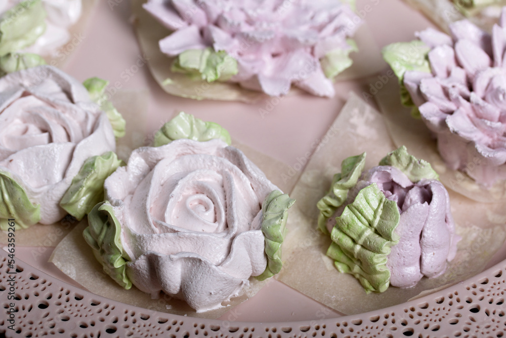 Marshmallow flowers on a tray. Zephyr flower buds. Homemade sweets. Against the background of pine boards. Shot close-up. Marshmallow flowers on a tray. Zephyr flower buds. Homemade sweets. Against the background of pine boards. Shot close-up.