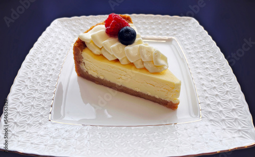 Classic plain New York Cheesecake slice on a white plate. Piece of cheesecake with fresh strawberries isolated background