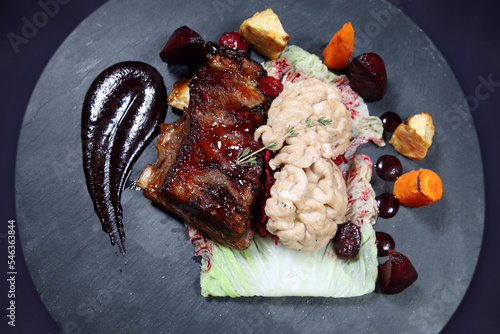 Cooked brain with ribs on a dark plate with isolated background. Top view