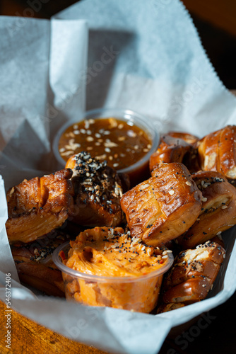 Tall photo of bar appetizer with Pretzel Bites and mustard and cheese sauce cups.