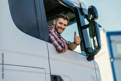 Leinwand Poster Truck driver sitting in his truck showing thumbs up