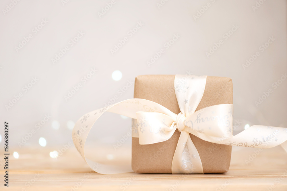 Christmas present in kraft paper on wooden table, eco friendly christmas holiday concept
