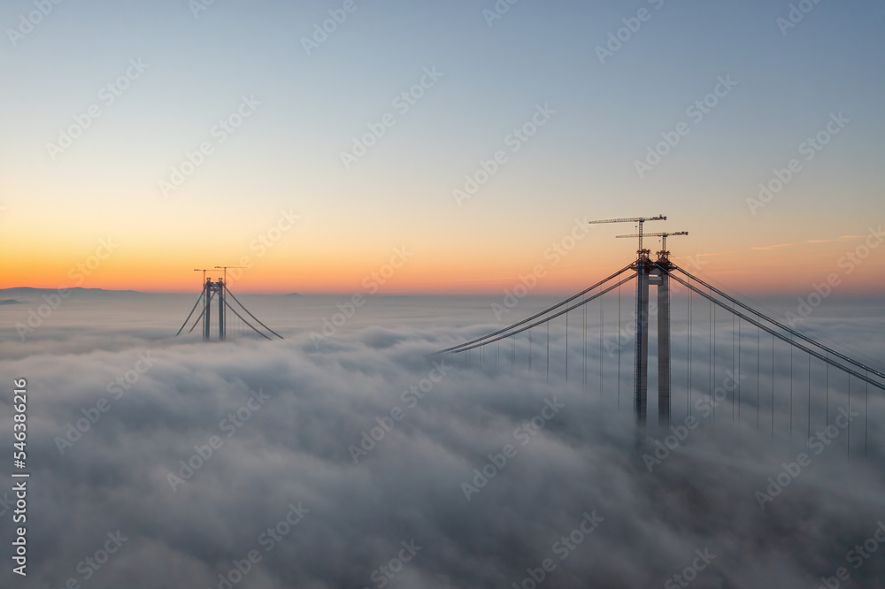 Panoramic aerial drone view from above of the suspended bridge over danube river, under construction, between Braila and Tulcea cities in Romania