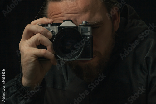 man holding Retro film photo camera isolated on black background soviet