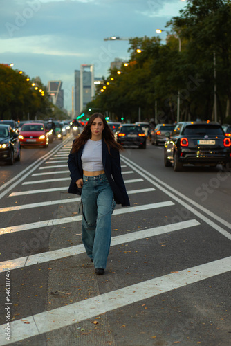 Woman walking on traffic island in city