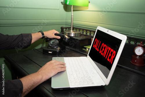 Call center,a message written on a laptop, a phone and a laptop in the picture and a message on the display. Retro Circle Dial Phone and modern notebook