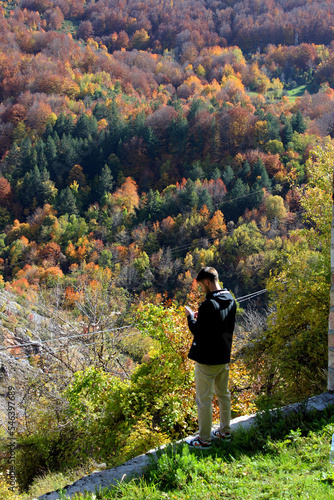 Man on the phone surrounded with nature in autumn colors 