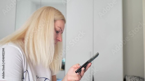 white-haired woman looks at the phone photo