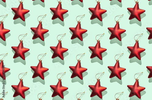 Pattern of red christmas stars on green pastel background