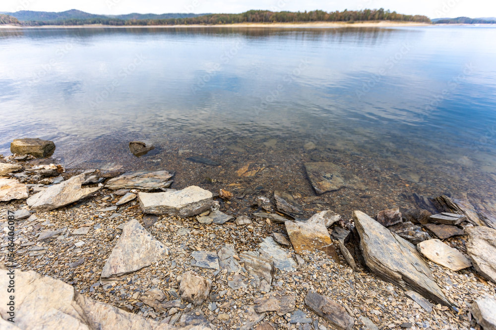 The shoreline of Broken Bow Lake in Oklahoma, USA. Beautiful view of lake and stones on the cost. The shoreline of Broken Bow Lake in Oklahoma, USA. Beautiful view of lake and stones on the cost.