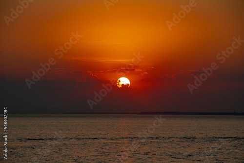 Amazing Black sea sunset. Clouds, water, orange landscape background. Drama juicy sky and red sun. Golden blue hour at the ocean romantic evening. Tropical island summer paradise. Wild rest camp