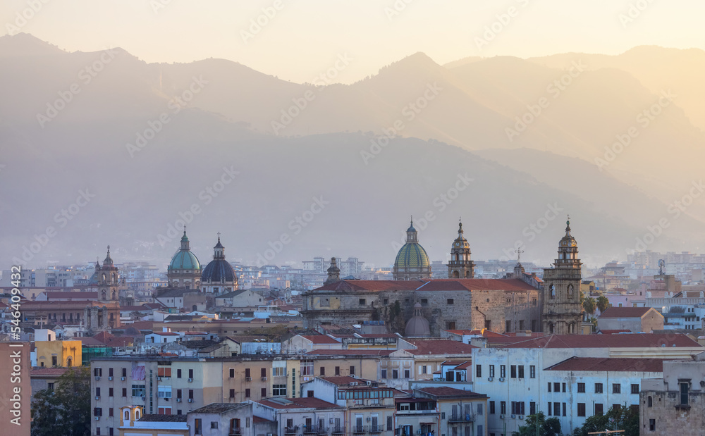 Residential Homes and Historic Church Buildings with mountains in background in Palermo, Sicily, Italy. Sunny Sunset Sky.