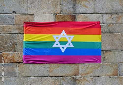 Gay pride rainbow flag with Star of David, pinned to a stone wall photo