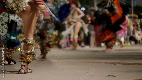 Group of people dancing traditional Aztec dance at night 