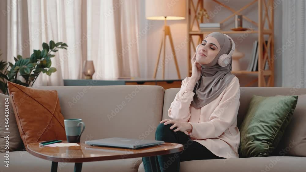 Young Muslim woman listens to music smiling happily at home Stock Video
