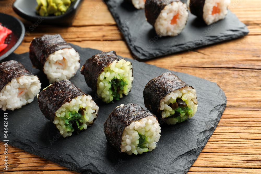 Tasty sushi rolls served on wooden table Tasty sushi rolls served on wooden table