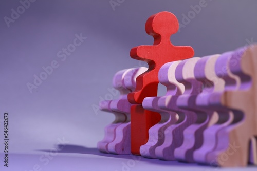 Fotografia Wooden figures with red one on purple background, closeup and space for text