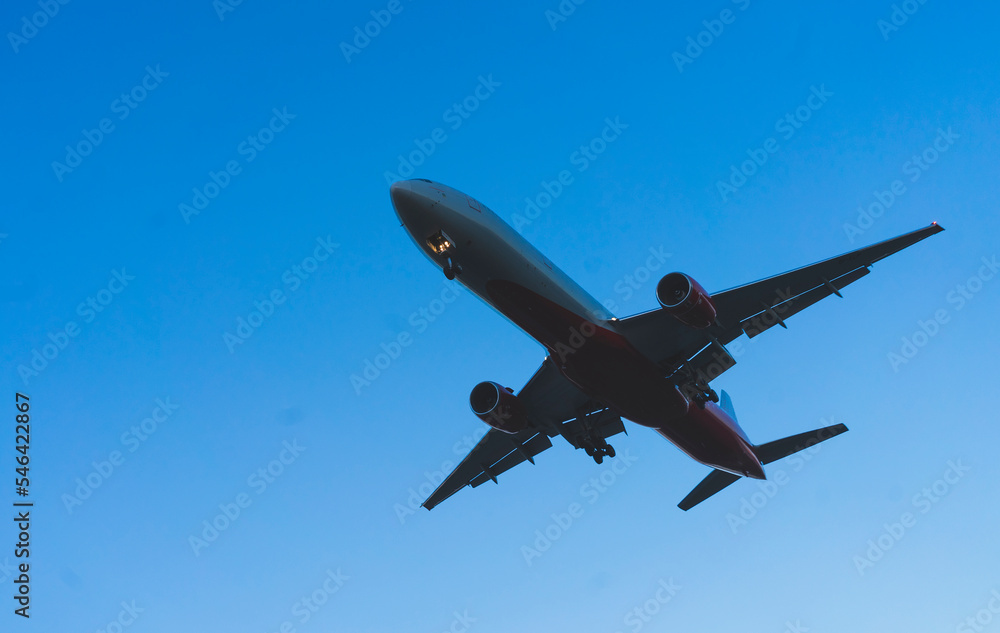 The silhouette of a passenger plane coming in for landing against the backdrop of the sunset sky. The silhouette of a passenger plane coming in for landing against the backdrop of the sunset sky.