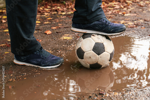 Man with soccer ball in muddy puddle outdoors, closeup © New Africa