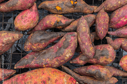 Top view Japanese sweet potato, with husk on resting on a grill grate.