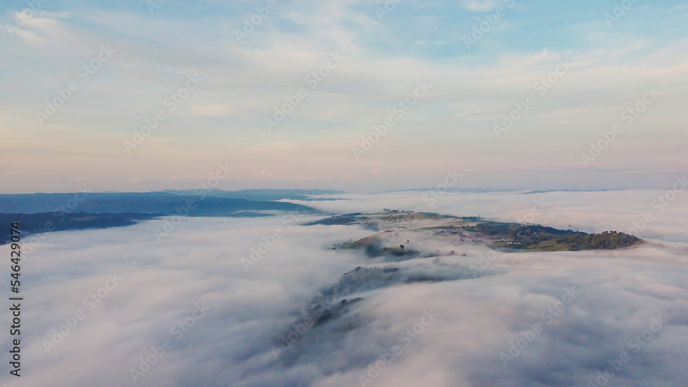 Thick fog in the mountains at dawn, Beautiful  sunrise and fog landscape.