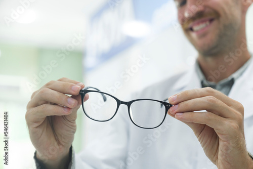 Optician suggesting new eyeglasses frame to clients.