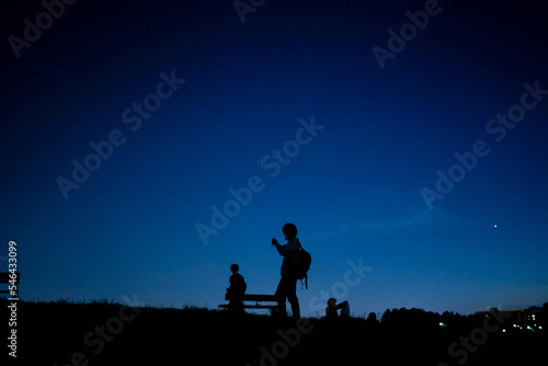 夜の丘を歩く人々