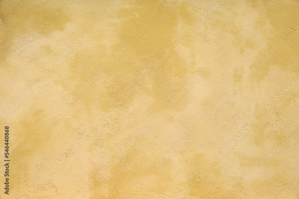 Textured wall in shades of yellow paint, as a graphic background
