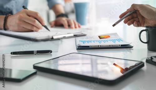 Cropped shot of Professional business partner consulting the strategy, using digital tablet and graph chart at office.