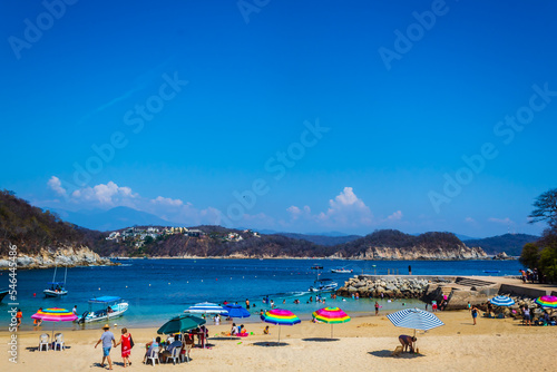 holidays in mexican beach with tourist walking in the sand, huatulco oaxaca  photo