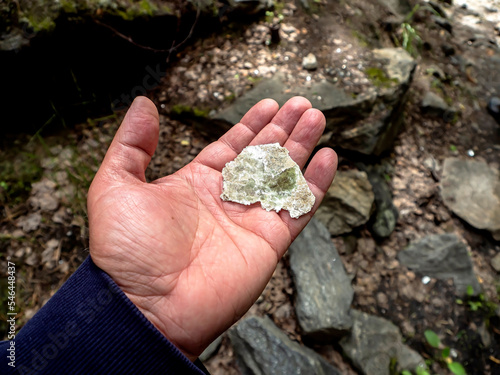 Canvas Print piece of transparent mica in the hands of a man