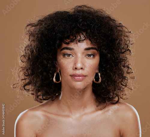 Portrait, skincare and black woman in studio for hair, skin and beauty, grooming and hygiene on brown background. Face, wellness and girl model with natural, afro and glam cosmetic with makeup