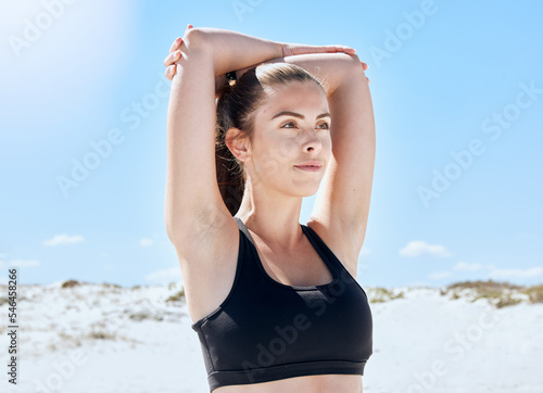 Beach, workout and arm stretching of a woman training in nature before running or yoga. Fitness, healthy and runner person outdoor relax in the sun after outdoor exercise, sport and wellness activity
