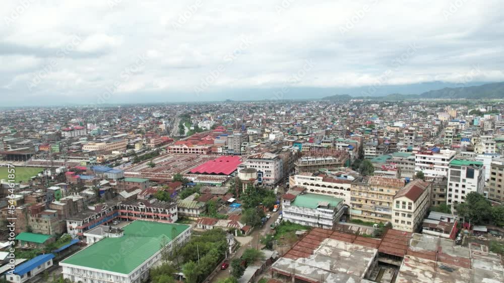 Aerial Drone Shot of Market Surrounded By Buildings, Bridge, And River In Imphal, India. Aerial Drone Shot of Market Surrounded By Buildings, Bridge, And River In Imphal, India.