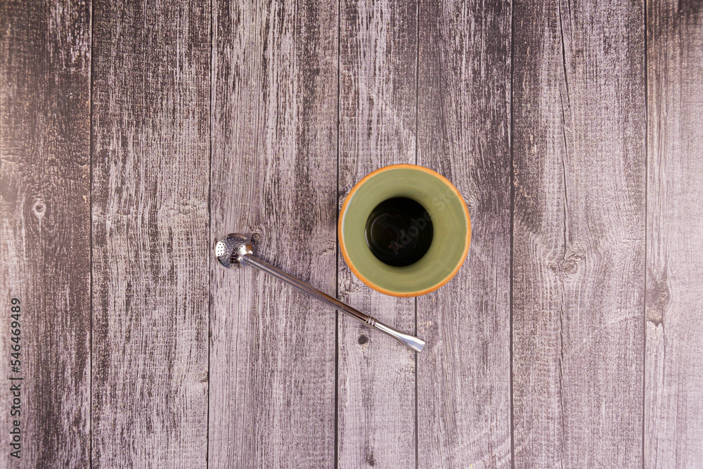 Clay mate calabash with bombilla on grey wood background Clay mate calabash with bombilla on grey wood background