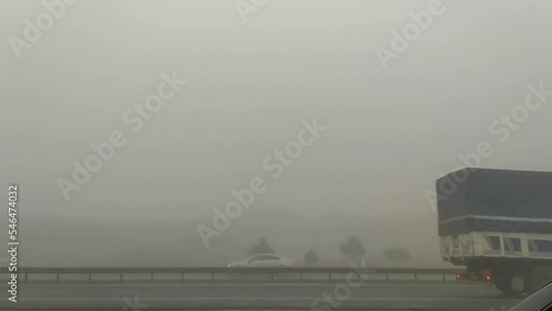 cars passing by foggy road