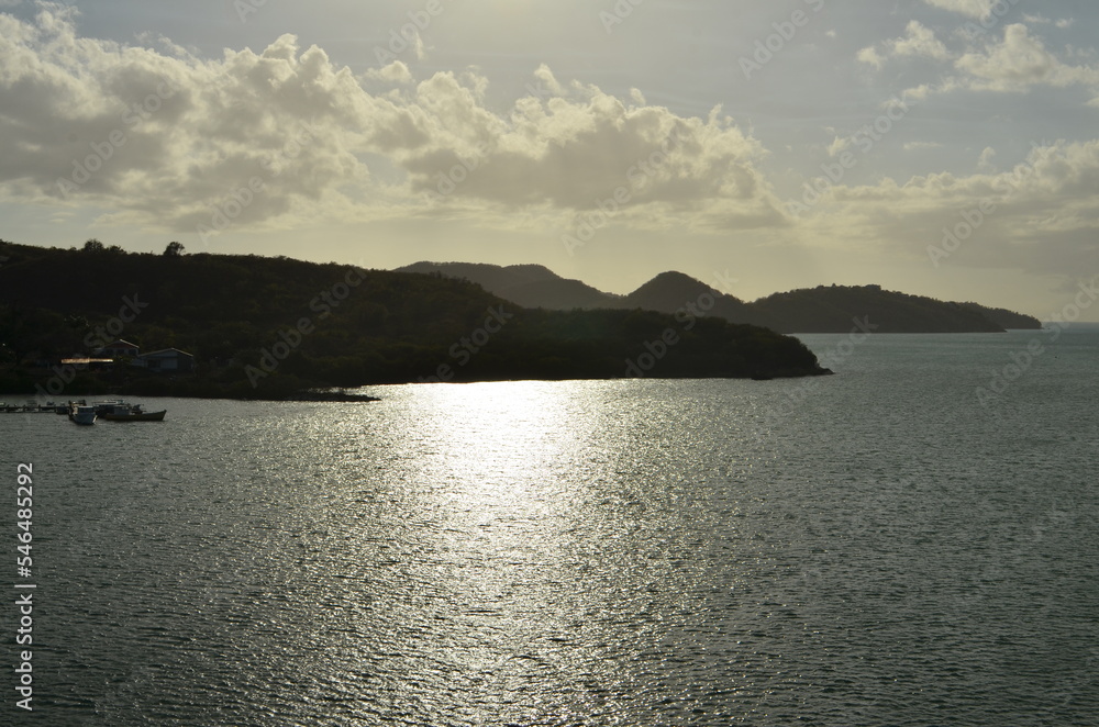 Caribic sun mirroring Water from above Mountains horizon
