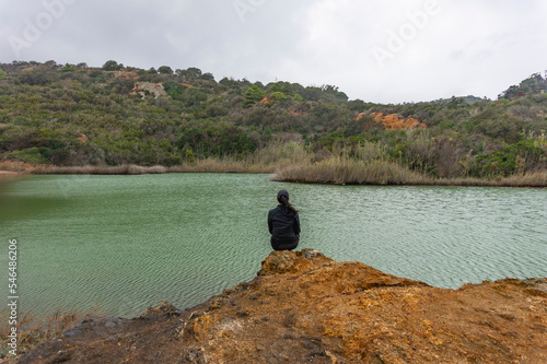 Donna seduta sulla sponda del lago, strane cose photo