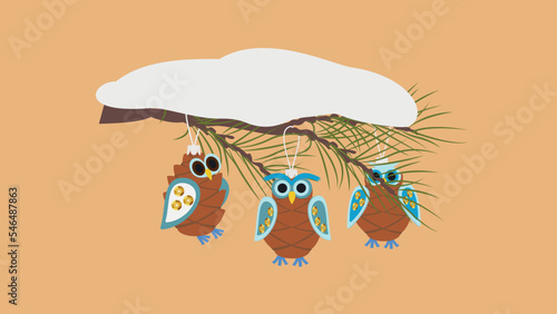 Christmas decorations in the form of owls from cones on a snow-covered branch