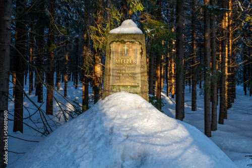 Stone memorial in the winter forest. Inscription: Warden Robert Melzer was fatally injured in an accident at this location on August 19, 1905 photo