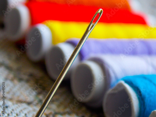 Sewing needle in close-up on the background of a set of threads