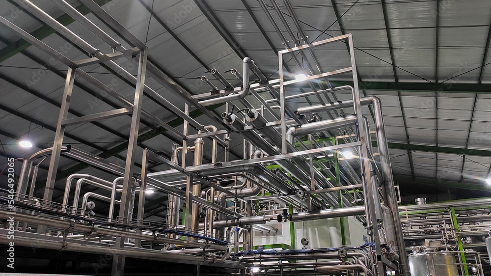 Stainless steel pipes in production room of factory to flow water and milk Stainless steel pipes in production room of factory to flow water and milk