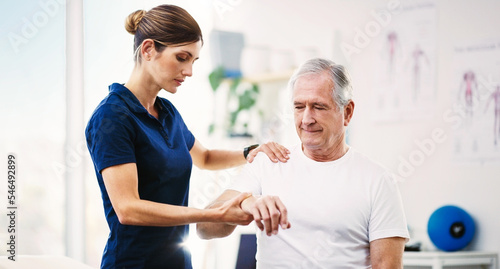 Nurse, patient and physical therapy for elderly care, medical or healthcare support at the clinic. Woman physiotherapist or chiropractor helping mature man in physiotherapy or arm stretching