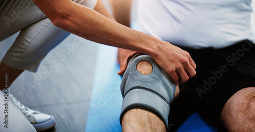 Physiotherapist hands, knee brace and man with injury, pain and torn muscle. Physiotherapy, male patient and female medical professional help, consulting and rehabilitation for leg and healthcare. © Sean A E/peopleimages.com