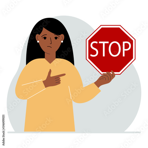 A woman holds a red stop sign in his hand.