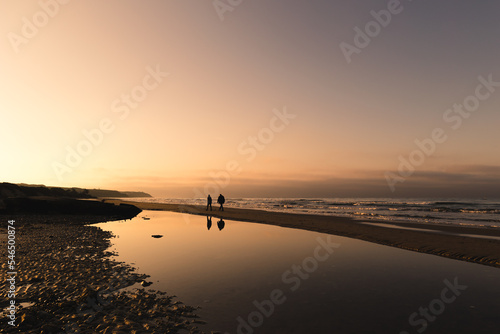 Couple se promenant sur la plage au coucher du soleil