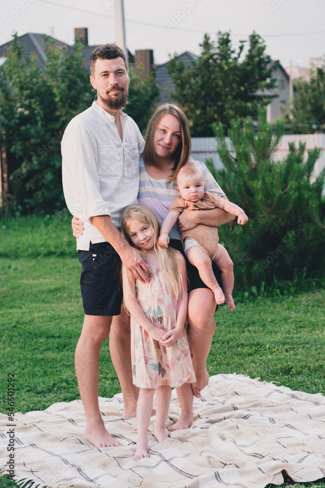Happy family of four enjoying together resting.on a blanket at summer Happy family of four enjoying together resting.on a blanket at summer
