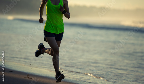 Healthy lifestyle young fitness woman running on sunrise beach