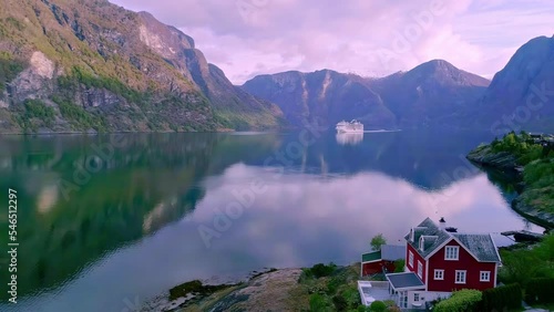 Tiny little lakeside house with a view of majestic mountain landscape, river Flåmsdalen and cruise at far, Norway photo