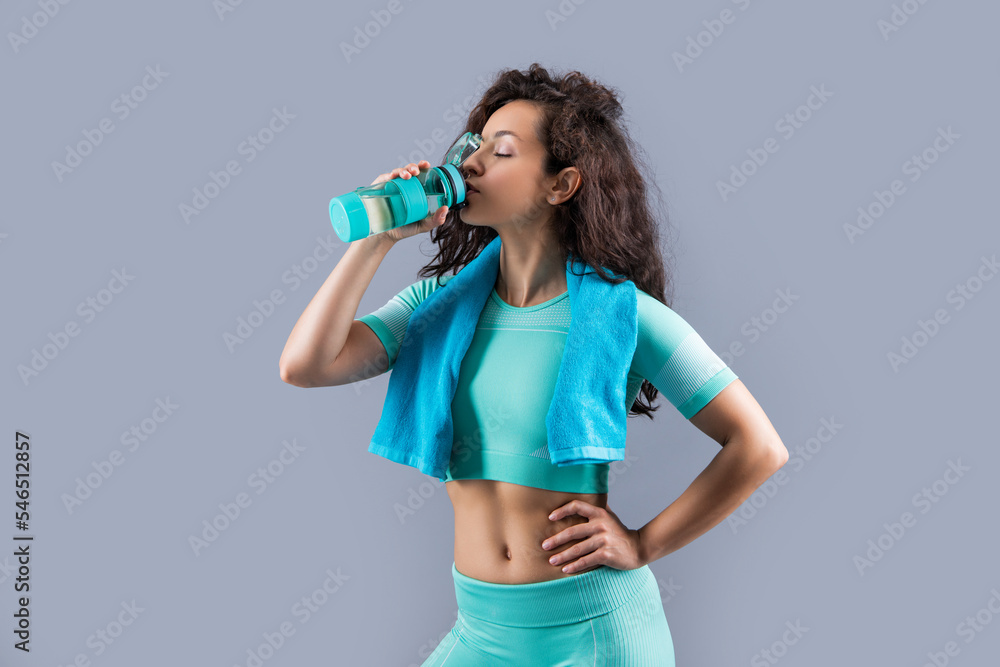 fitness woman with sport towel drinking water in studio. fitness woman hold towel drinking water fitness woman with sport towel drinking water in studio. fitness woman hold towel drinking water